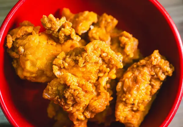 Chrupiący kurczak karaage w czerwonej misce. Idealna przekąska na imprezę.