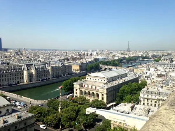 Vue panoramique de Paris, zone 1 à 3, avec la Seine, des bâtiments historiques et la Tour Eiffel au loin.