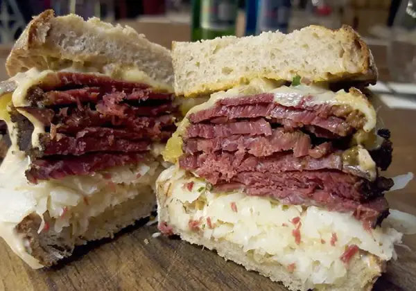 Pyszny reuben sandwich z grubymi plastrami wołowiny, kiszoną kapustą i serem, podany na chlebie żytnim.