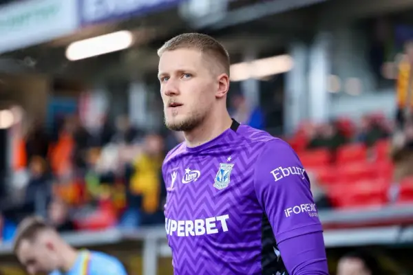 Bartosz Mrozek, bramkarz Lecha Poznań, w fioletowej koszulce z charakterystycznym wzorem.