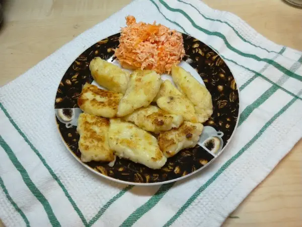 Usmażone pierogi ruskie z serem i ziemniakami, podane z surówką z marchewki.