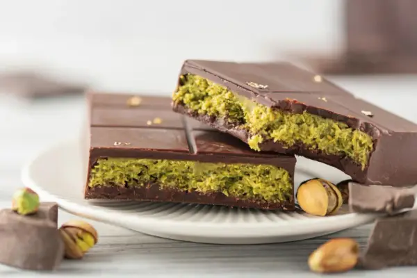 Schokolade mit Pistazienfüllung, inspiriert vom Dubai Schokolade Rezept. Goldene Blättchen zieren die dunkle Schokolade.