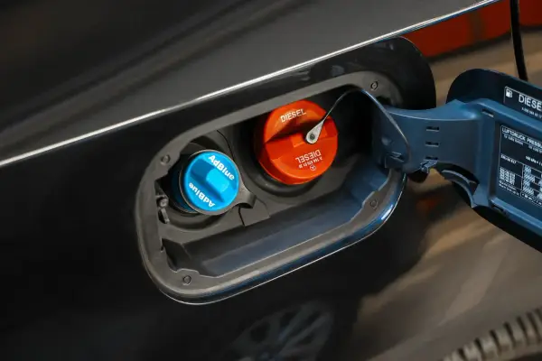 Niebieski korek AdBlue i pomarańczowy korek Diesel w klapce wlewu paliwa. W ten sposób sprawdzisz poziom AdBlue w swoim samochodzie.