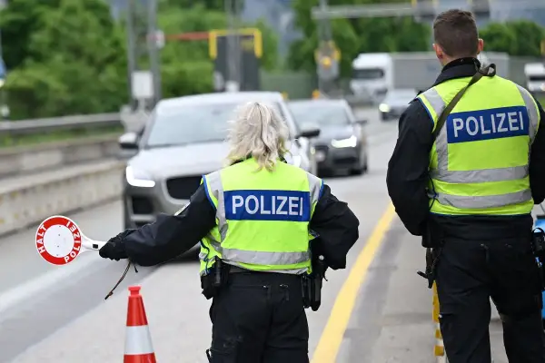 Policjanci kierują ruchem na trasie w Zgorzelcu. Jeden z nich trzyma znak "STOP".