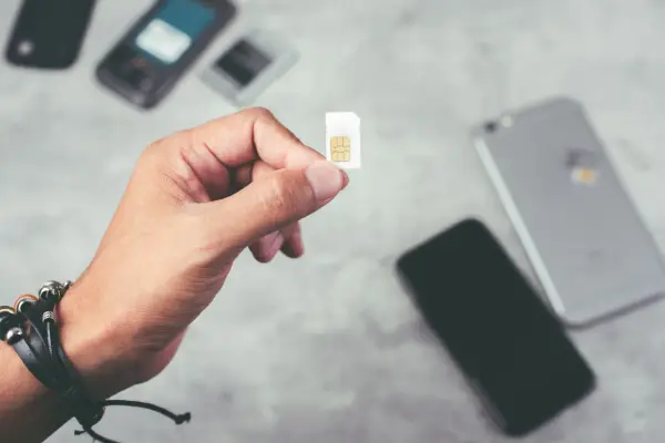 Dłoń trzyma kartę SIM, gotową do włożenia do telefonu. To idealne rozwiązanie dla osób szukających internetu na kartę bez umowy.