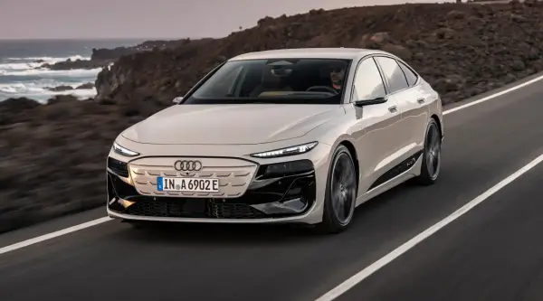 Eleganckie Audi A6 e-tron sunie po malowniczej drodze nad oceanem.