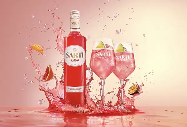 Sarti Spritz w towarzystwie owoców i orzeźwiających bryzgów. Idealny aperitif na letnie wieczory.