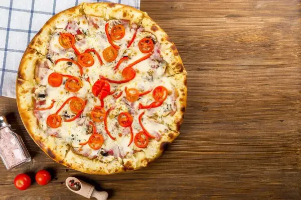 Pyszna pizza z pomidorkami i papryką, idealna na Pizza Hut promocje w lokalu.