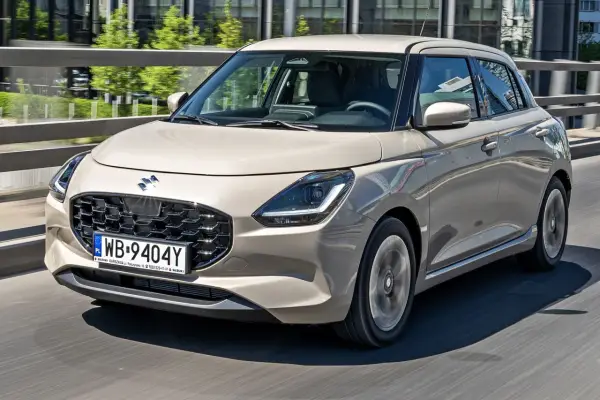 Nowy Suzuki Swift w beżowym kolorze, z nowoczesnym grillem i światłami LED. Sprawdź aktualne suzuki swift - ceny i oferty.