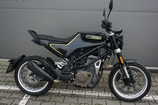 Czarny motocykl Husqvarna Svartpilen 401 z żółtymi akcentami, gotowy na miejskie przygody.