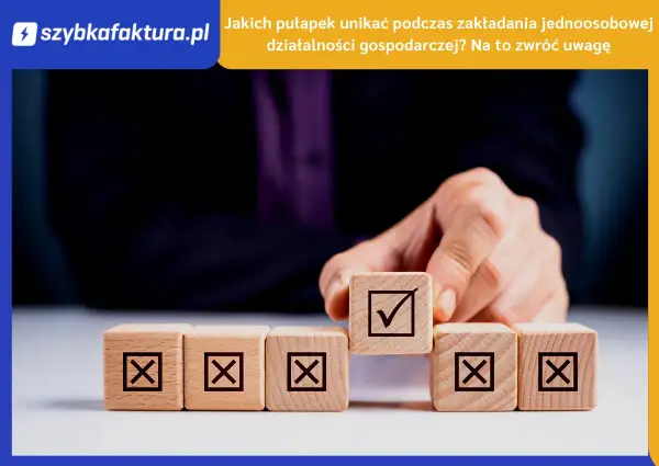 Dłoń układa kostki z symbolami. Jedna z nich, z zaznaczonym ptaszkiem, symbolizuje sukces w jdg.