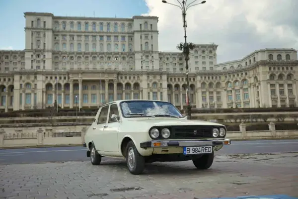 Biała Dacia 1300 na tle monumentalnego Pałacu Parlamentu w Bukareszcie.