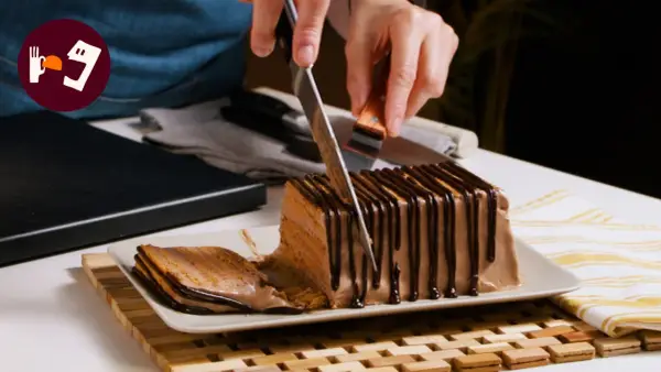 Cortando una porción de la deliciosa tarta de queso casera de la abuela, cubierta con chocolate.