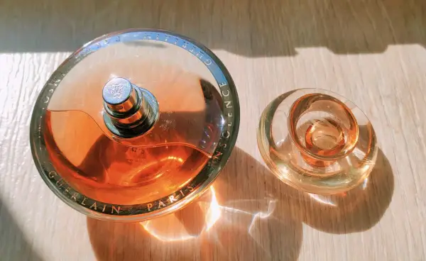 Perfumy Guerlain Insolence w szklanych flakonach, z wygrawerowaną nazwą marki i produktu.