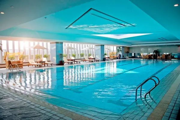 Relaks w hotelu z basenem na Podlasiu. Długi, błękitny basen z leżakami i parasolami, idealny na wakacje.