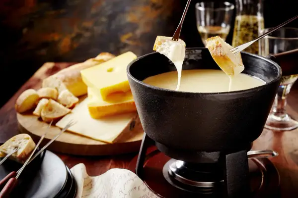 Pyszne fondue serowe z chrupiącym pieczywem, idealne na wspólny wieczór.