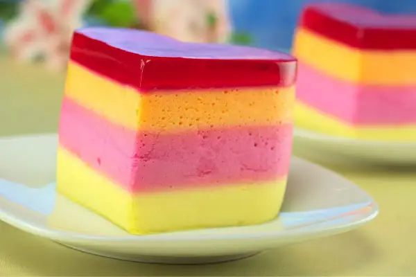 Kolorowa galaretka z mlekiem skondensowanym, warstwowa jak tęcza, kusi smakiem.