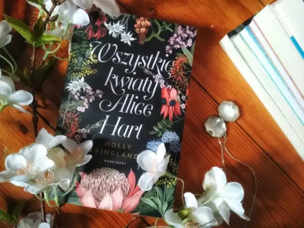 Wszystkie kwiaty Alice Hart otoczone białymi kwiatami, na drewnianym tle.