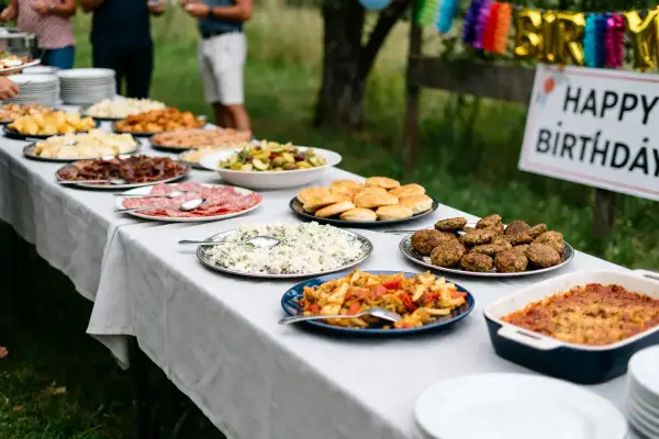 Buffet d'anniversaire en plein air : salades, charcuterie, boulettes et gratins composent ce repas d'anniversaire original et pas cher.