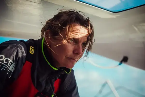 Anne Claire Le Berre, concentrée, le regard intense, le visage marqué par le soleil et le vent, sur un bateau.