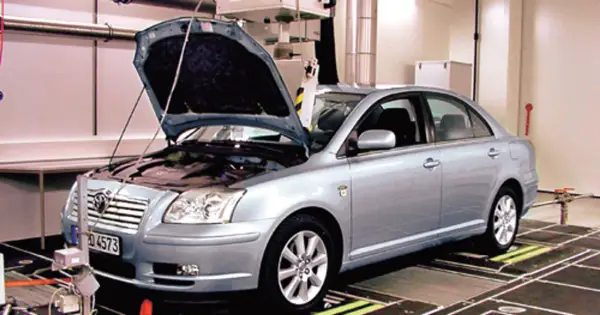 Srebrna Toyota Avensis 2.0 D4D z otwartą maską stoi na stanowisku diagnostycznym.