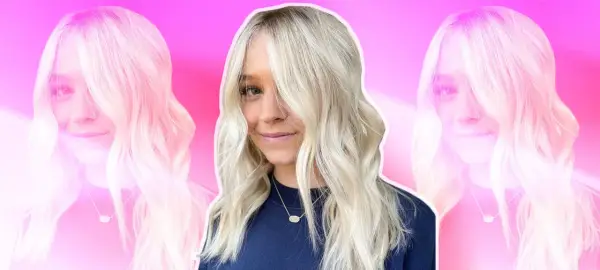 Mujer sonriente con cabello rubio platino, peinado en ondas suaves. Las mechas platinadas resaltan su rostro.