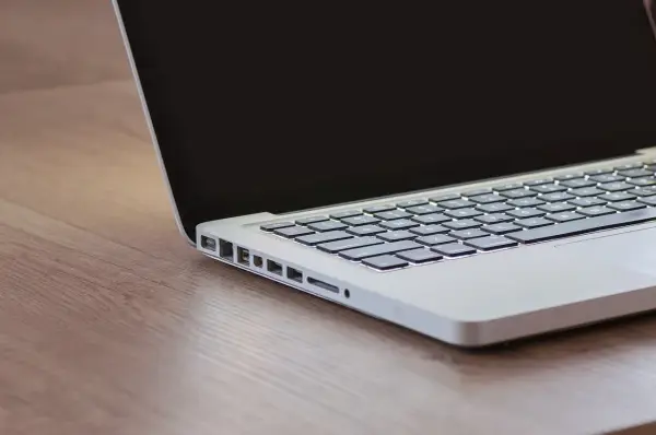 Czekam na inspirację, gdy czarny ekran w laptopie odbija światło.