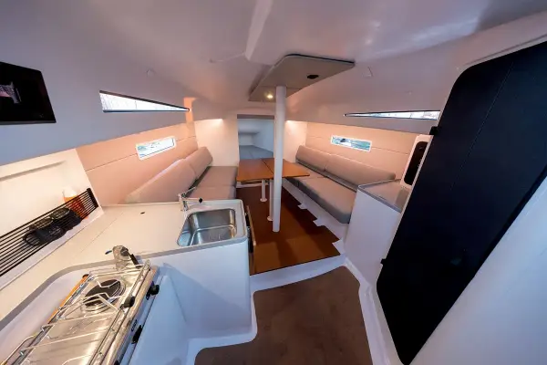 Intérieur d'un voilier moderne, avec cuisine, salon et table. Les premiers 30 pieds offrent un espace confortable pour la vie à bord.