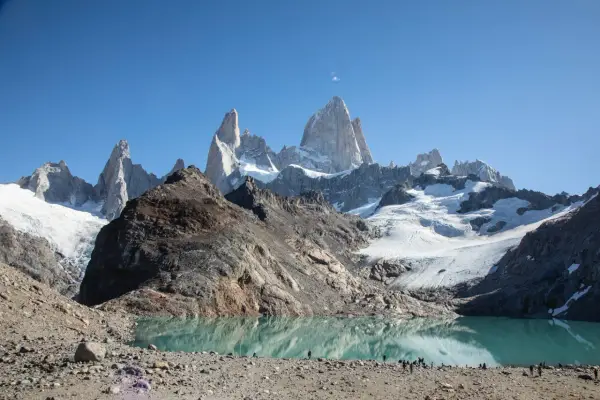 Majestätische Berge spiegeln sich in einem türkisfarbenen See. Die Szene vermittelt das Gefühl, dass dies die **Patagonien beste Reisezeit** ist, um diese atemberaubende Landschaft zu erleben.