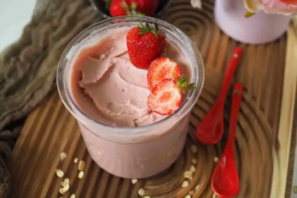 Cremiges Kefir Eis mit frischen Erdbeeren garniert, bereit zum Genießen.