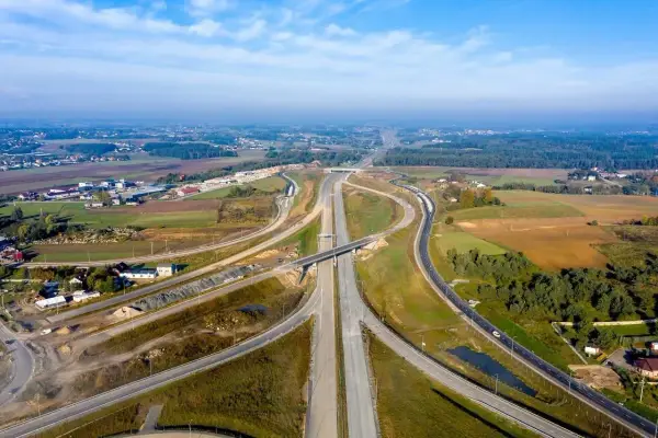 Rozbudowa trasy gdańsk, widok z lotu ptaka na węzeł drogowy w otoczeniu pól i lasów.