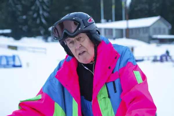 Äldre man i färgglad skidjacka och hjälm, redo för backen. Kanske en veteran från Edsbyn skidor.