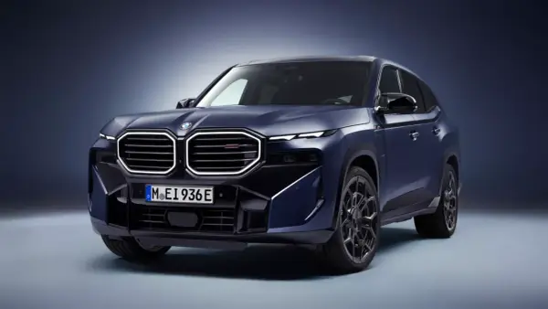 Mroczny, lśniący BMW XM w kolorze granatowym prezentuje swoją masywną sylwetkę i charakterystyczny grill.