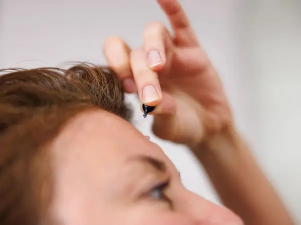 Dłoń trzyma kapsułkę z serum. To celimax retinal shot, który zaraz zostanie zaaplikowany na skórę.