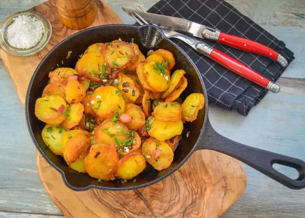 Goldbraune Bratkartoffeln mit Speck und Schnittlauch in der Pfanne. Perfekt als Beilage, denn dazu passt fast alles!