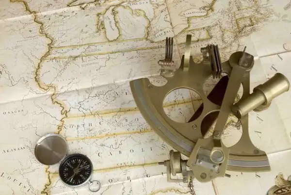 Un sextant et une boussole sur une carte ancienne, évoquant la navigation et l'exploration.