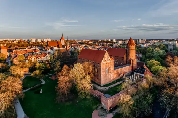 Zamek w Malborku, gdzie kiedyś rezydowali krzyżacy, w blasku zachodzącego słońca.