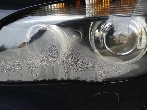 Widoczne parowanie lamp w samochodzie, drobne kropelki wody pokrywają klosz reflektora, tworząc mglisty efekt.