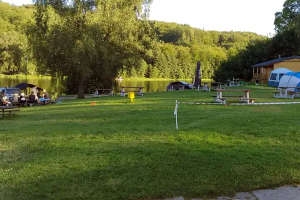 Relaks nad jeziorem, piknikowe stoły i namioty tworzą sielski krajobraz. To miejsce to prawdziwa **mała Szwajcaria Przywidz**.