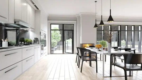 Cocina moderna con encimera de mármol negro y **suelos para cocinas sin obras** de madera clara. Mesa de comedor con sillas negras y chimenea.