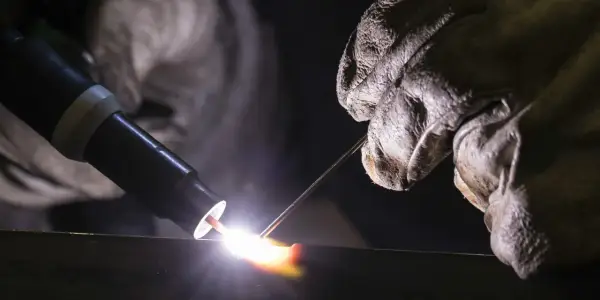 Un soldador usa una antorcha para crear una chispa brillante, demostrando que es la soldadura.