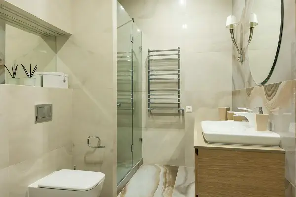 Baño moderno con ducha de cristal, lavabo y WC. Ideal para instalar extractor baño y mantener el ambiente fresco.