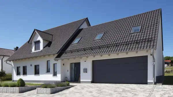 Nowoczesny dom z garażem i ciemnym dachem. Kąt nachylenia dachu 10 stopni zapewnia estetyczny wygląd i dobrą ochronę.