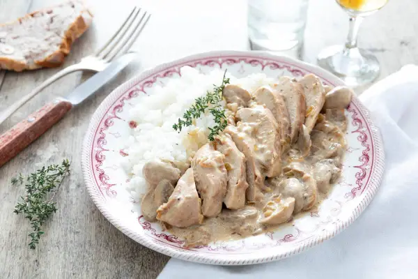 Délicieuse recette filet de poulet à la crème et champignons, servi avec du riz blanc et garni de thym frais.