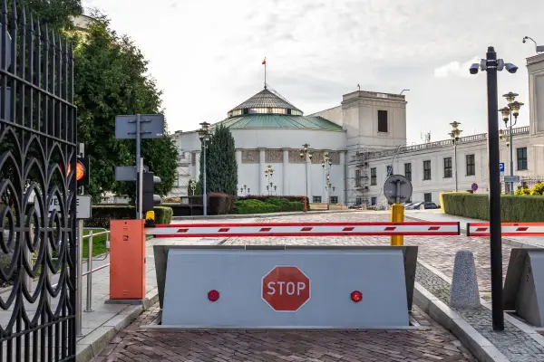 Brama wjazdowa do Sejmu, symbolizująca immunitet poselski, z barierą i znakiem STOP.