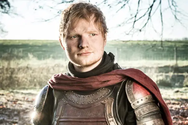 Ed Sheeran w zbroi, jakby z Gry o Tron, pozuje na tle natury.