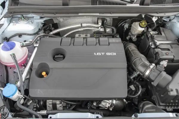 Silnik 1.6T GDI z widocznymi elementami osprzętu i płynów.