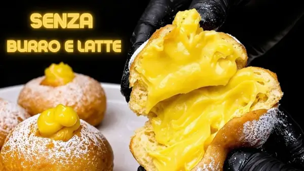Bomboloni alla crema, soffici e ripieni, senza burro e latte. Un dolce invitante, pronto per essere gustato.