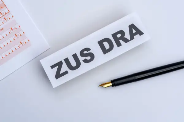 ZUS DRA na papierze, obok czarne pióro. Dokumenty do wypełnienia.
