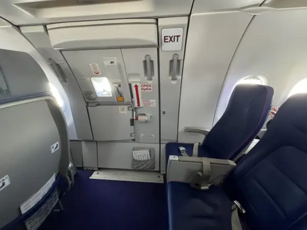 Wizz rozkład miejsc w samolocie Wizzair. Widok na rząd siedzeń i drzwi wyjściowe.
